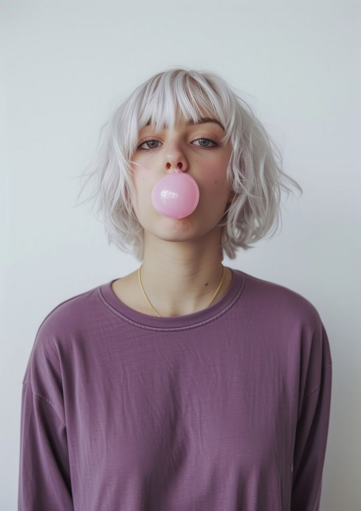 Young woman blows off a pink portrait purple hair.