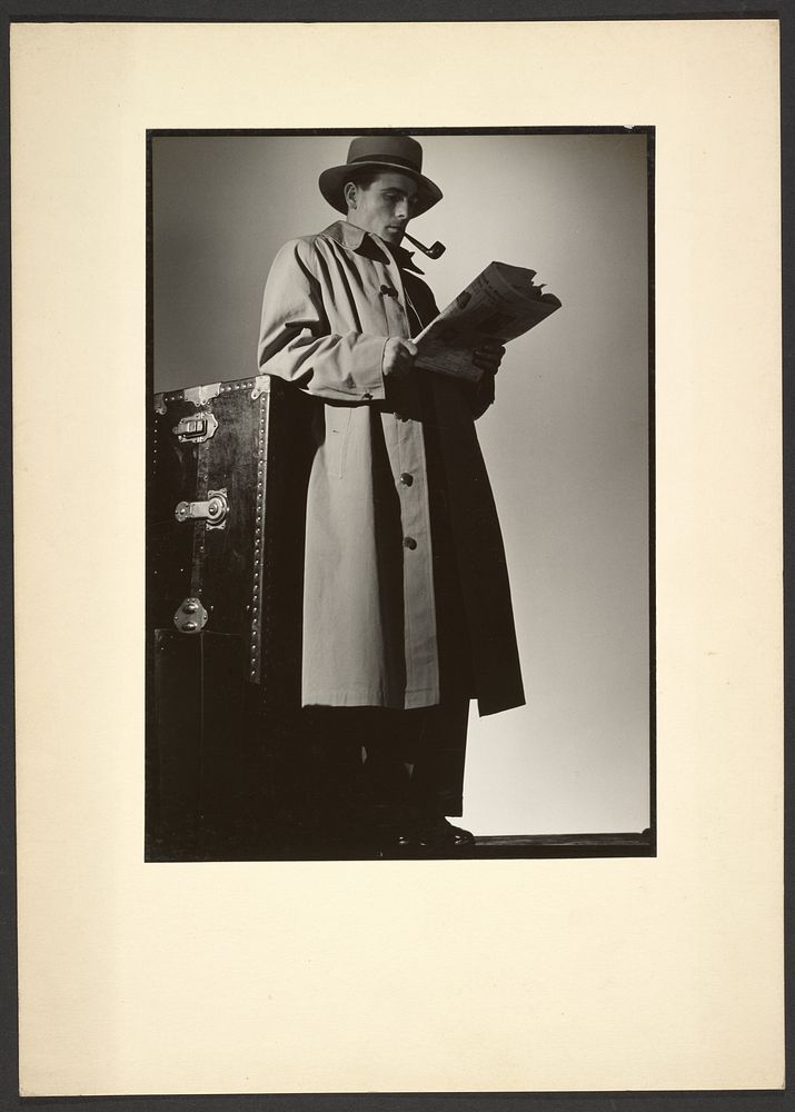 Man in trench coat reading newspaper by Günther Krampf