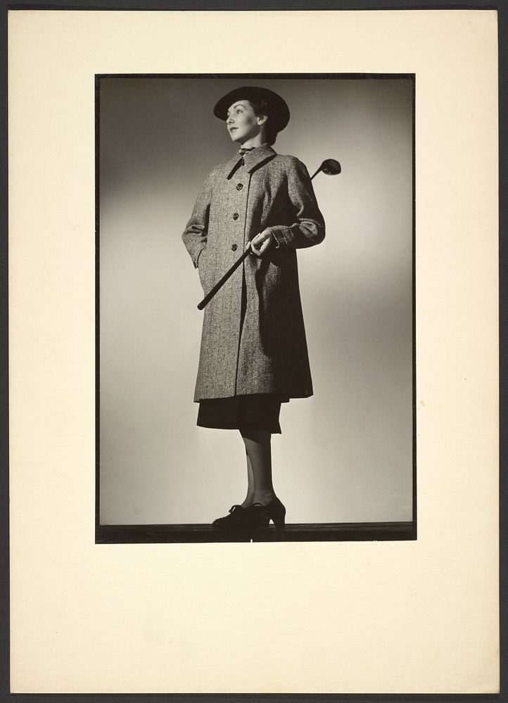 Woman modeling coat with golf club by Günther Krampf