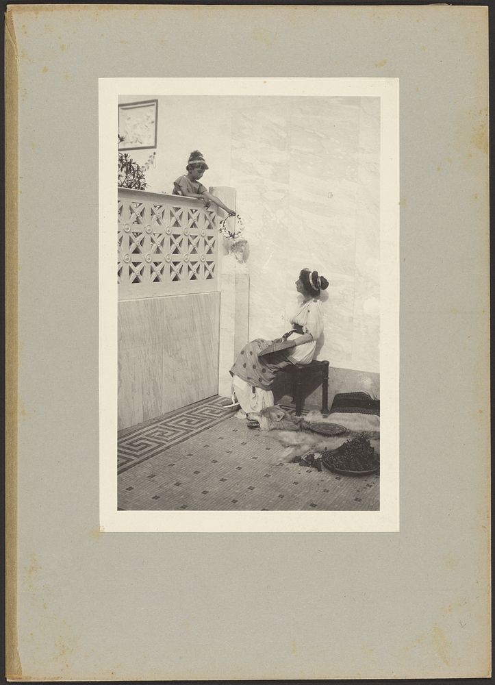 Young Boy on Balcony Offering a Flower Head Wreath to a Seated Woman Holding a Fan by Guido Rey