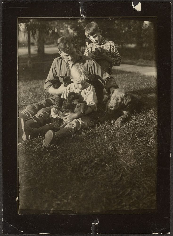 Man with Children and Puppies in Yard by Louis Fleckenstein