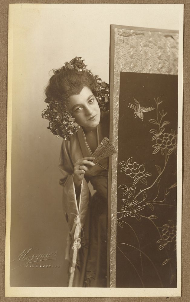 Woman in Oriental costume, looking around Oriental screen by A Louis Mojonier