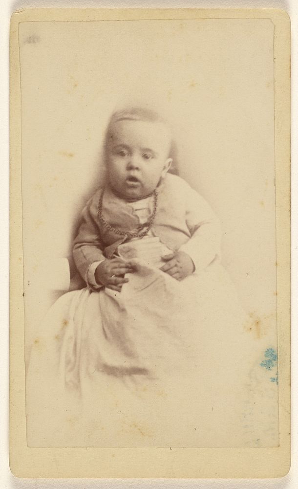 Unidentified baby with necklace, blanket wrapper around lap by G W Bryant