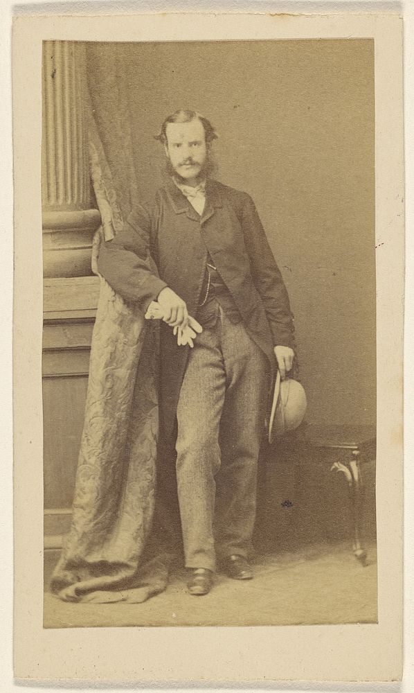 Unidentified man with moustache & muttonchops, holding gloves in one hand, a hat in the other by F Schwarzschild
