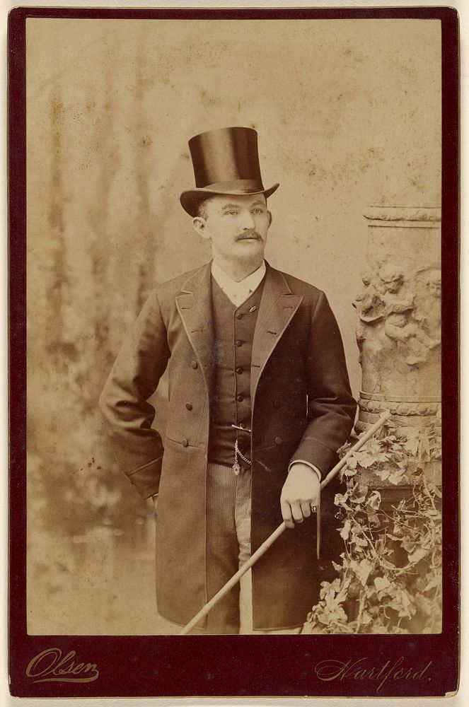 Unidentified man with moustache, wearing top hat, standing by Olsen