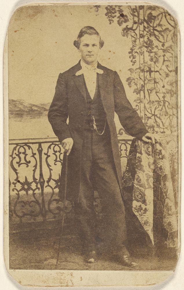 Unidentified well-dressed man holding a walking stick