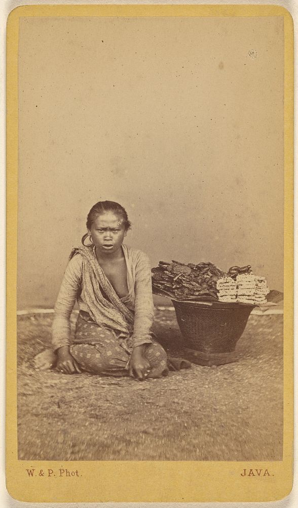 Javanese woman seated with legs crossed, basket at side by Woodbury and Page
