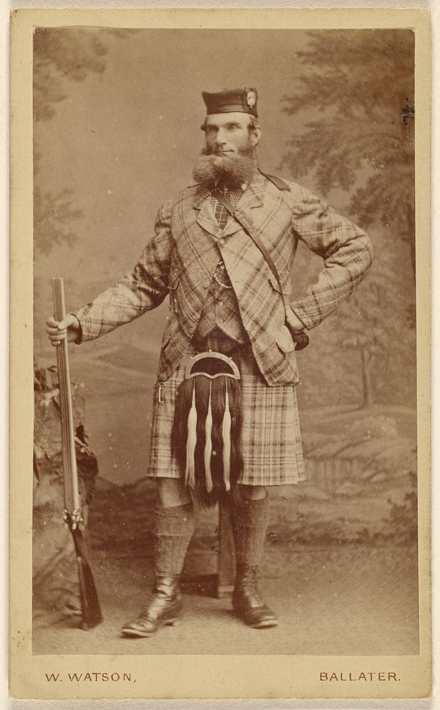 Unidentified bearded Scottish man wearing a kilt, holding a rifle, standing by W Watson
