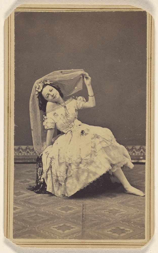 Unidentified female dancer posed on a hassock wearing a veil on her head by S G Sheaffer and Company
