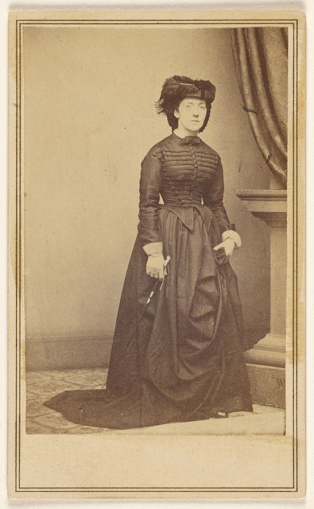 Unidentified woman wearing a hat and long dark dress. by Mathew B Brady