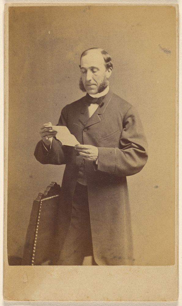 Man with muttonchops reading a letter, standing by J A Whipple