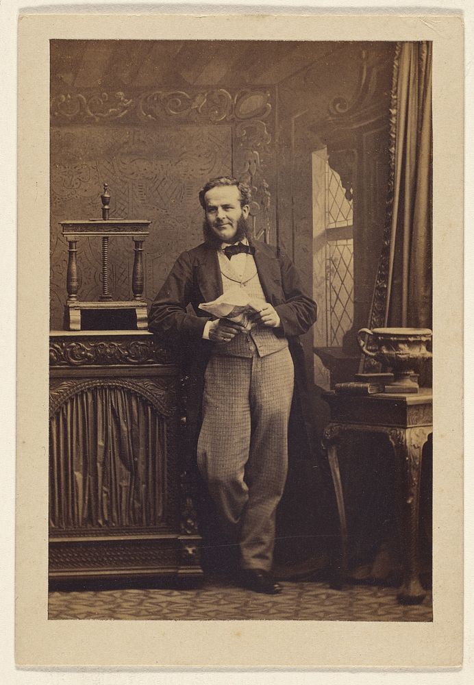Unidentified man with muttonchops, standing, holding a newspaper by Camille Silvy