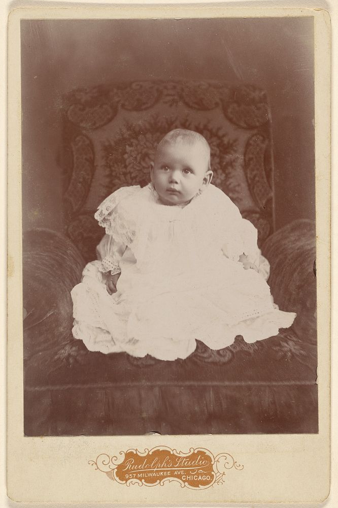 Baby girl in white dress, seated by Louis Rudolph