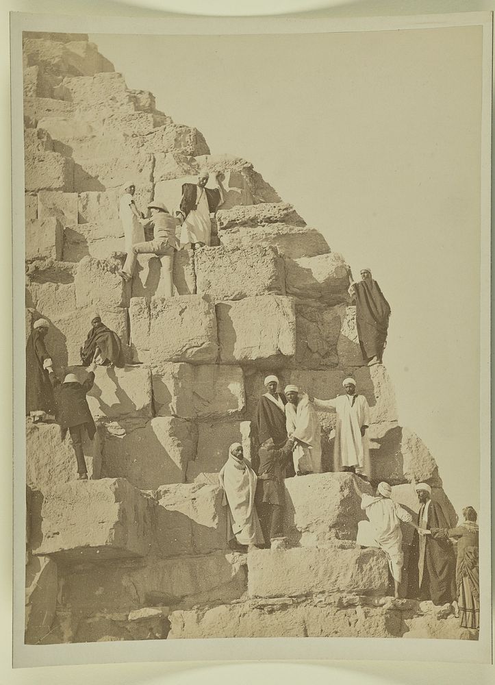 Men standing on steps of pyramid by Pascal Sébah
