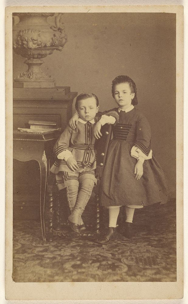 Two unidentified children: boy, seated, girl, standing by Carey and Raynard