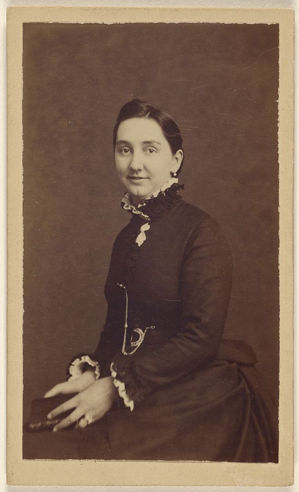 Unidentified woman wearing a dark dress, holding a book, seated