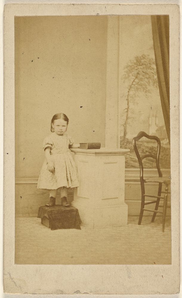 Unidentified little girl, standing on covered box