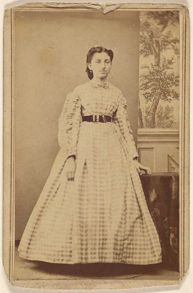 Unidentified woman in checkered dress, standing