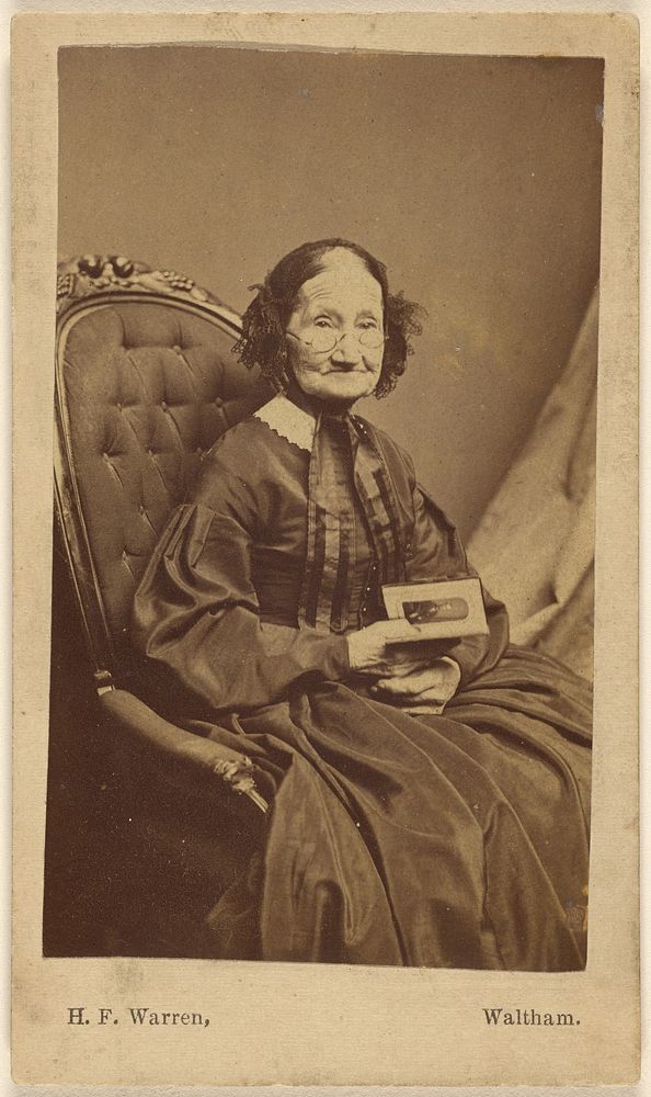 Elderly woman holding a photograph by Henry F Warren