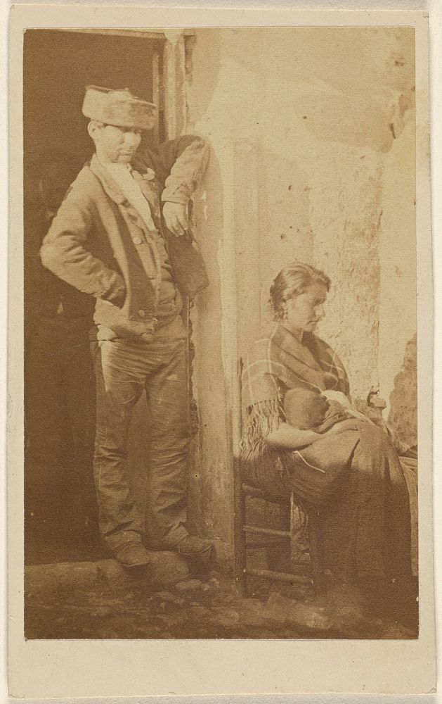 Man standing next to a seated woman holding a baby