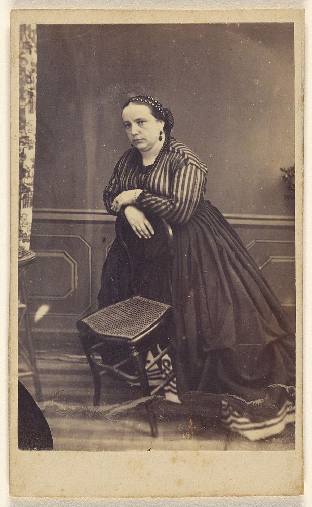 Unidentified woman wearing a striped blouse, standing, leaning on a chair by Lespinasse
