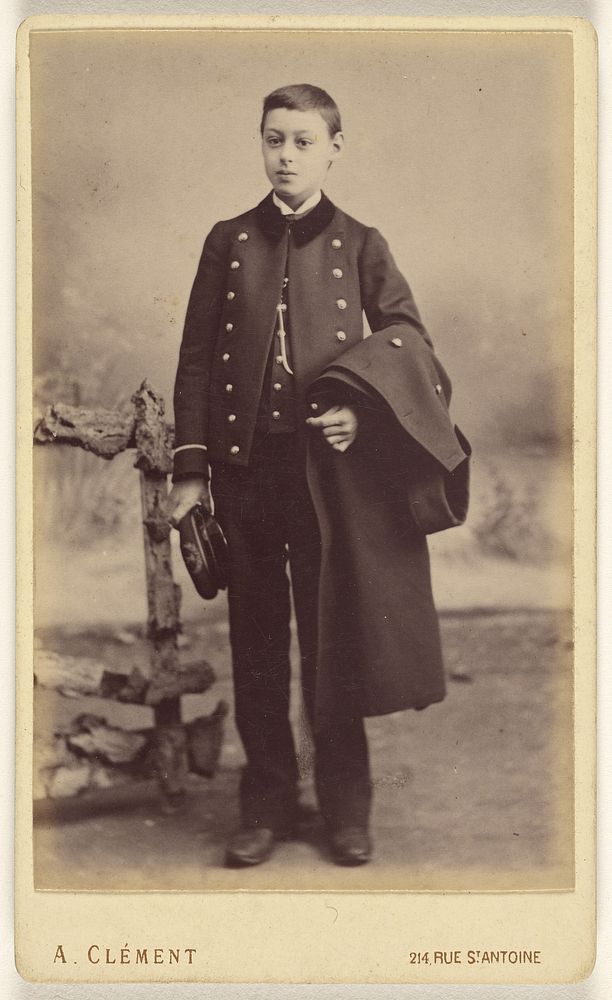 Unidentified well-dressed young boy standing, holding his cap in his right hand, his coat over his left arm by A Clément