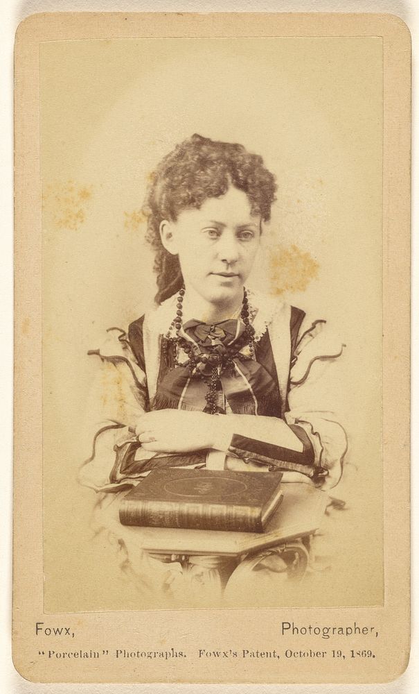 Unidentified woman seated with arms crossed, books in foreground by Egbert Guy Fowx