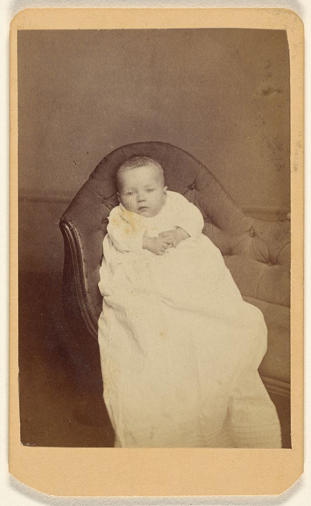 Unidentified baby seated on a couch by D Hinkle