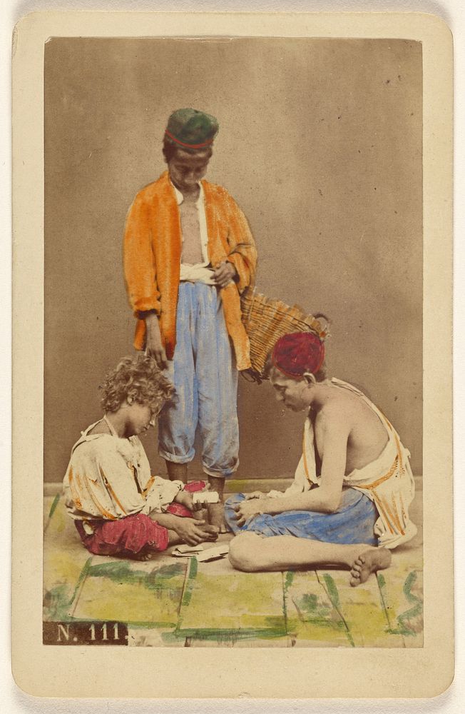 Unidentified man with basket standing, plus two boys seated playing cards by Giorgio Conrad