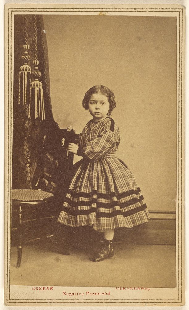 Unidentified little girl standing, holding a chair back by Jeremiah M Greene