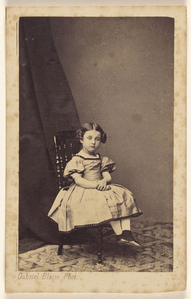 Unidentified little girl with hair up on both sides, seated, with hands clasped by Gabriel Blaise