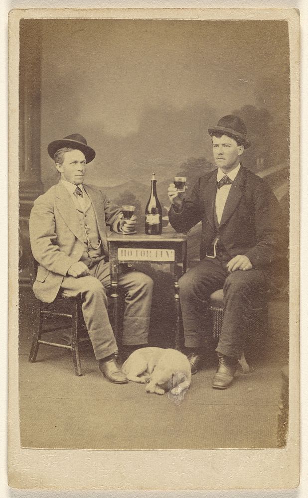 Two men drinking at a table, a dog lying at their feet by Leaman and Lee