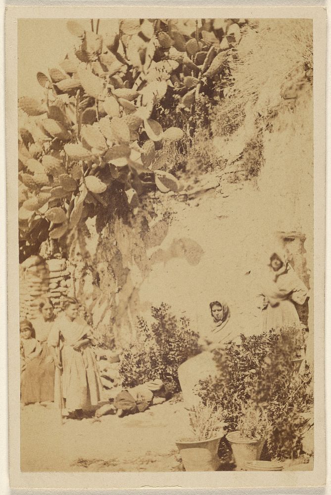 Unidentified women and children near a hill with cacti
