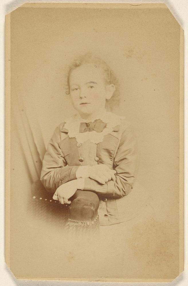 Unidentified little girl with arms crossed, resting on chair arm, printed in vignette-style by William H Seeler
