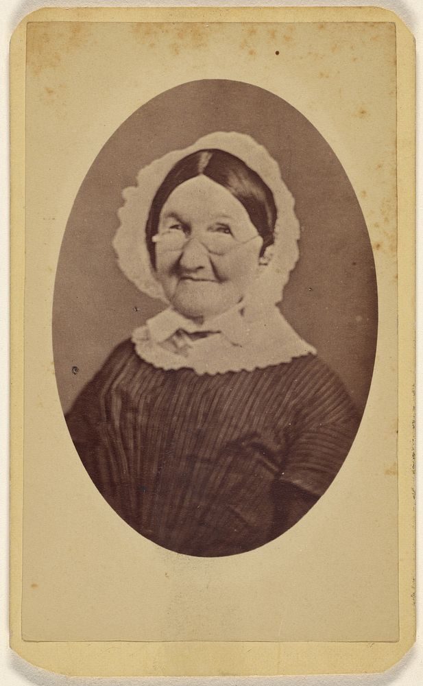 Unidentified elderly woman wearing wire-rimmed glasses and a bonnet, printed in quasi-oval style by L L Scheitzer