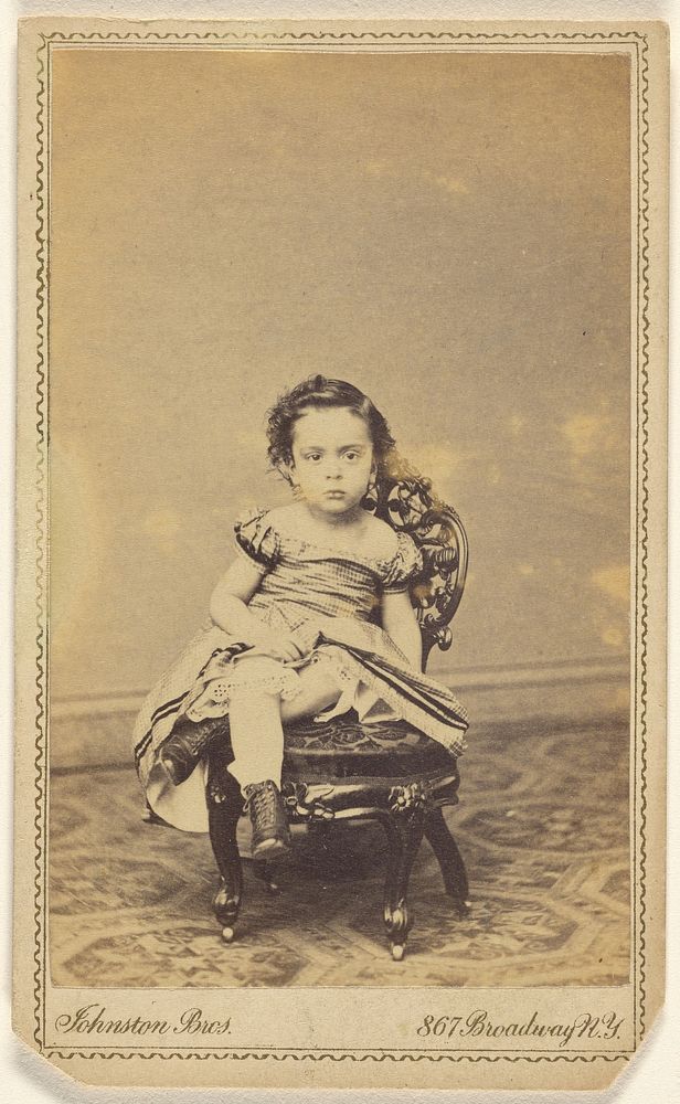 Unidentified little girl seated in a small chair by Johnston Brothers R G and  Johnston