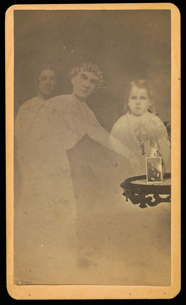 Three "spirits" with a photograph on a table propped against a vase with flowers by William H Mumler and Helen F Stuart