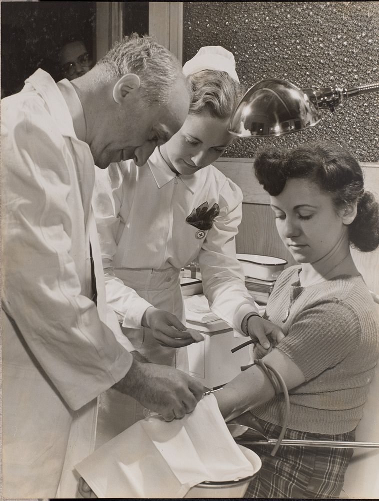 Doctor and nurse insert a needle into a woman's arm by Arnold Eagle