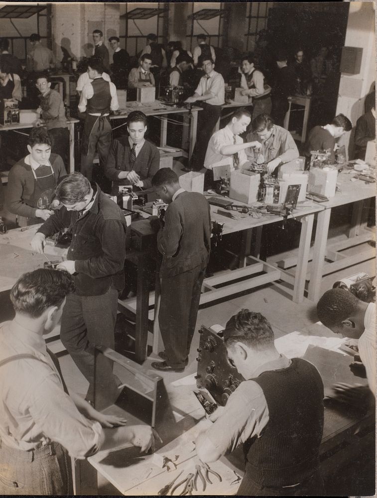Large group of young men work on machines by Arnold Eagle