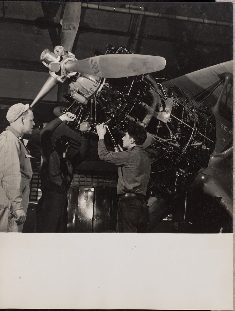 Three men work on an airplane engine by Arnold Eagle