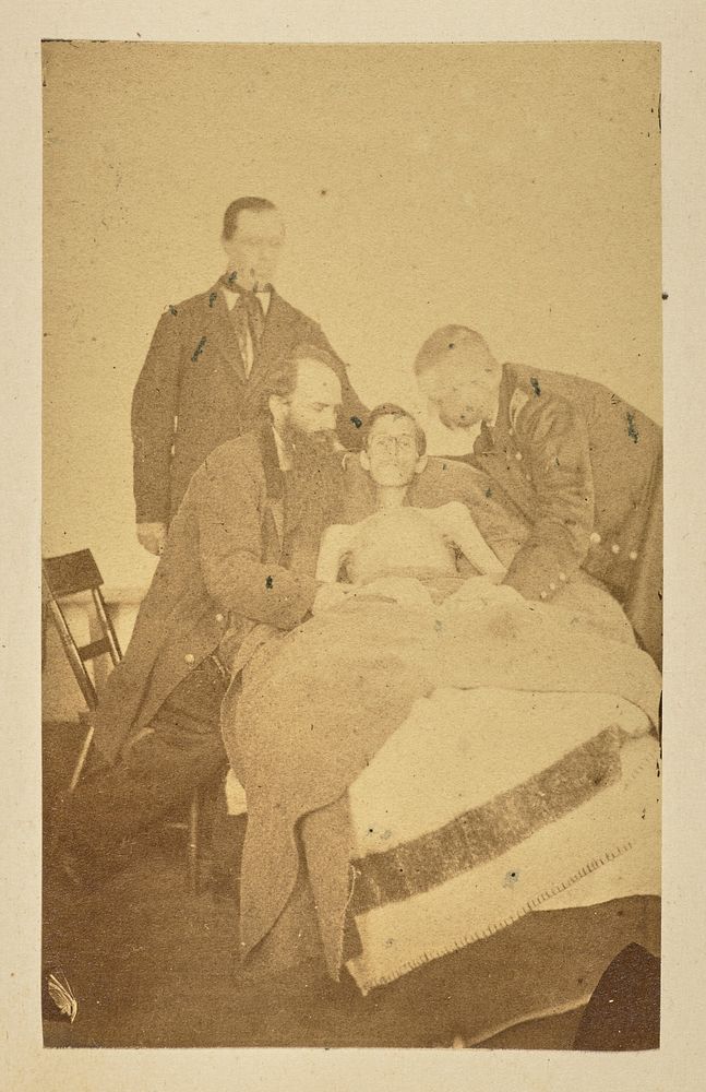 Bedridden soldier surrounded by doctors