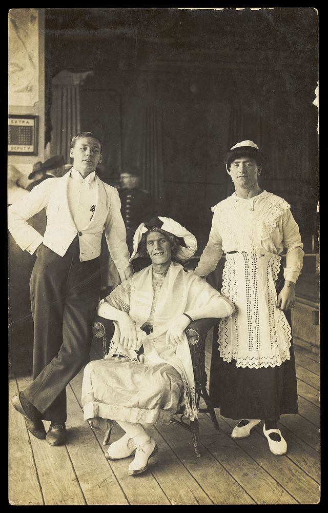 Three soldiers, two in drag, pose in costume. Photographic postcard, ca. 1920.