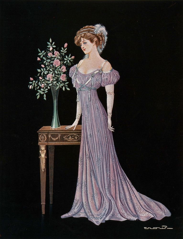 A woman is wearing a fashionable gown and a headpiece with feathers, she is leaning on a table with a vase of flowers…