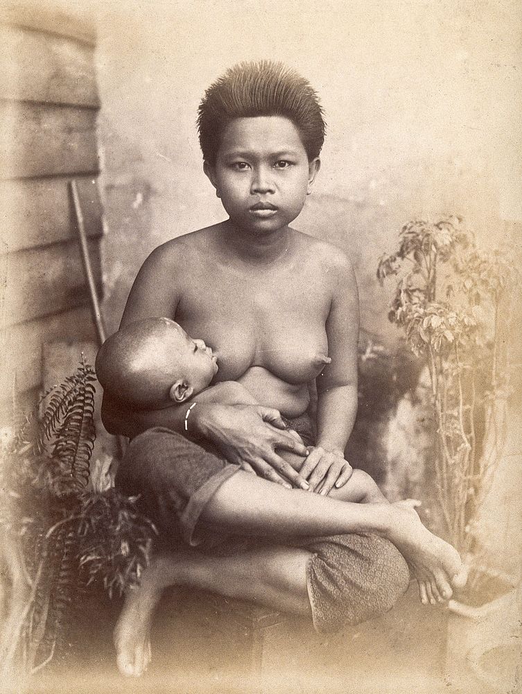 Thailand: a woman breastfeeding her child seated cross-legged: studio portrait . Photograph, 1880/1900.