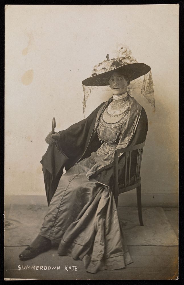 A convalescent soldier (Lance-Corporal R.C. Thomas) poses in drag, wearing a silk dress and sitting with a mourning veil.…