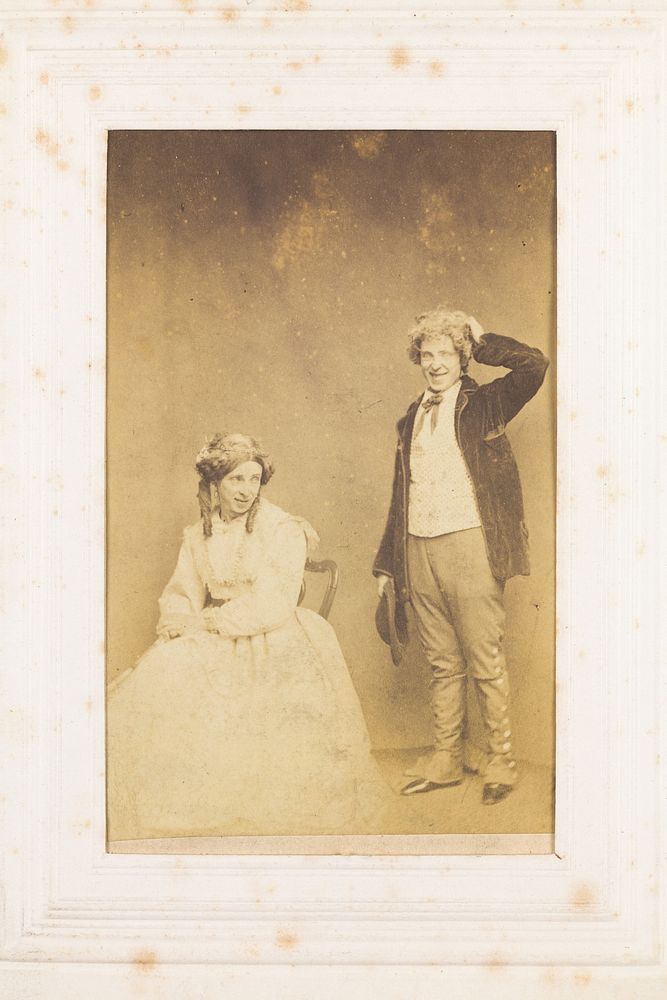 Two men, one in drag, posing with comic expressions. Photograph, 189-.