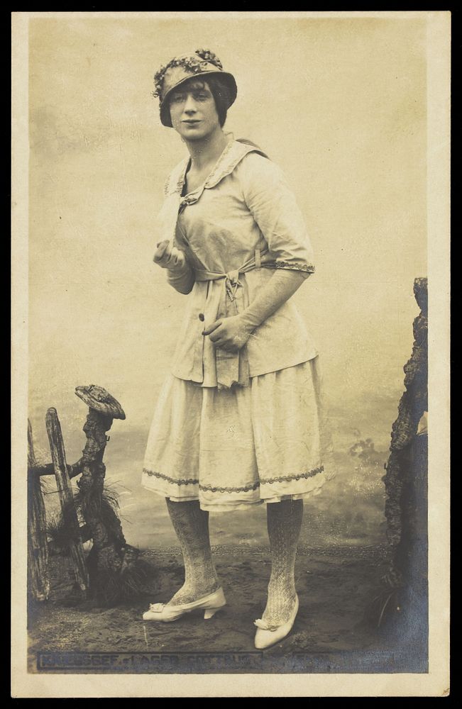 An actor, in drag, performing English theatre at a prisoner of war camp in Cottbus. Photographic postcard, 191-.