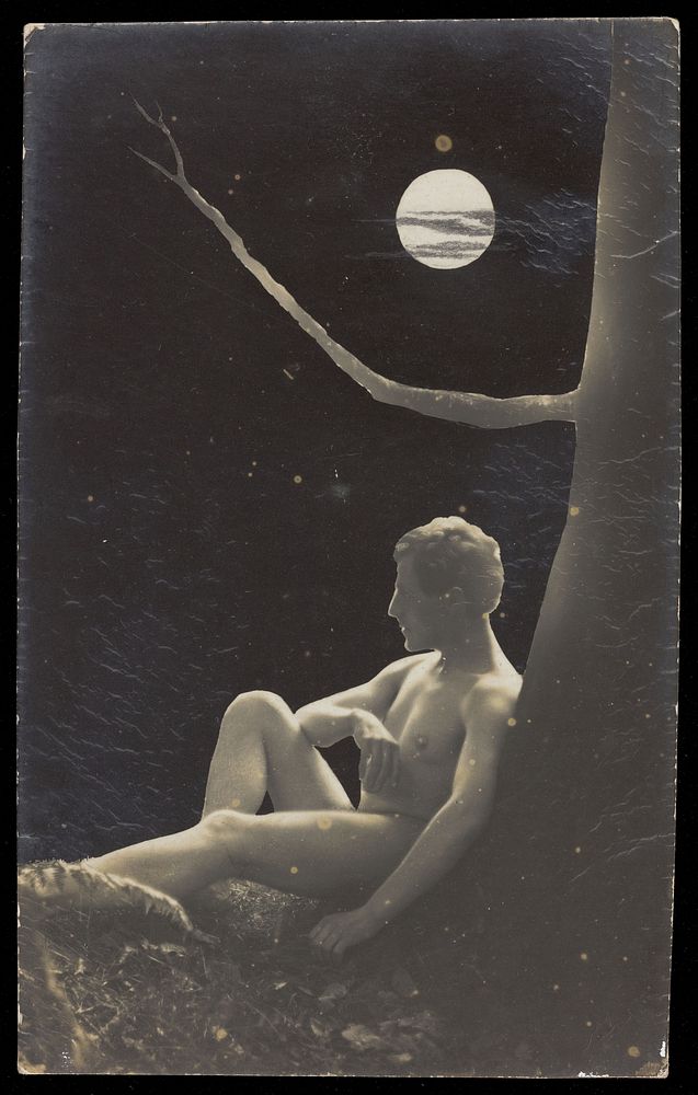 A naked man sits under a tree in the moonlight. Photographic postcard, 190-.