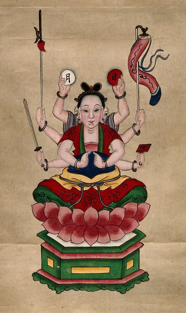 The deity Guanyin (Kuan Yin) seated on a lotus throne with eight arms, carrying a sword, axe, lantern, a swastika and two…