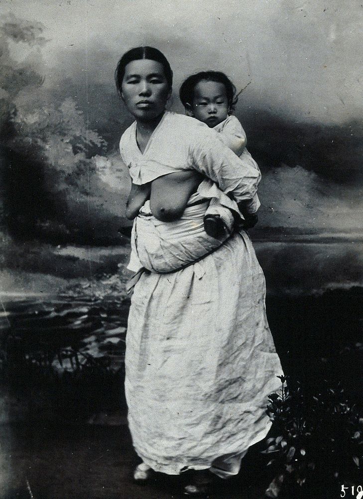A Korean  woman, carrying a baby on her back.
